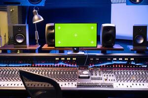 leeg studio controle kamer met groene scherm geïsoleerd monitor, professioneel paneel bord en technisch uitrusting gebruikt in muziek- post productie. equalizer en schuifregelaars Aan klankbord. foto