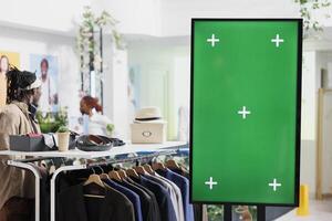 digitaal bord met groen scherm voor kleren merk Promotie bespotten omhoog in boodschappen doen centrum. slim Scherm met chroma sleutel voor kleding nieuw verzameling advertentie in mode winkel foto
