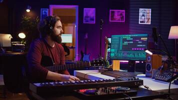 geschoold artiest opname zijn gitaar lied naar mengen Aan daw software, werken met elektronisch klankbord apparatuur. audio ingenieur produceren soundtracks of geluid Effecten in zijn huis studio. camera b. foto