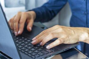 dichtbij omhoog schot van de vrouw met mooi handen in de bedrijf kleding, werken Aan de laptop in de kantoor. concept foto