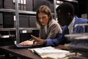 onderzoekers werken laat Bij nacht in archiveren kamer, analyseren crimineel geval bewijs zoeken voor nieuw aanwijzingen. detectives onderzoeken onderzoek bestanden, lezing slachtoffer rapport. wet handhaving concept foto