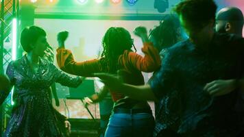personen hebben pret Bij dans partij in nachtclub, genieten van modern dans strijd naar tonen uit funky beweegt Aan dans vloer. gelukkig jong volwassenen dansen en jumping in de omgeving van Aan muziek- mengen. foto