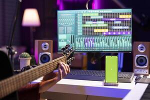 beginner zanger proberen naar Speel akoestisch gitaar gebruik makend van online tutorials met groene scherm Aan tablet, beoefenen instrument in huis studio. muziek- producent aan het doen repetitie door spelen nieuw liedjes. foto