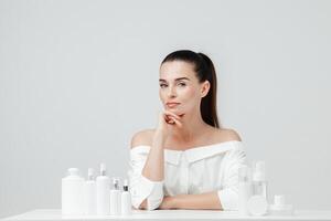 midden- oud, volwassen vrouw tonen kunstmatig producten branding model. dagelijks huidsverzorging en lichaam zorg routine. natuurlijk kunstmatig room, serum, wit flessen verpakking, bio biologisch Product foto