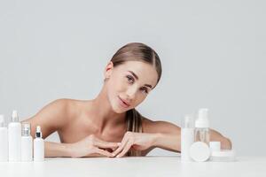 vrouw tonen kunstmatig producten branding model. dagelijks huidsverzorging en lichaam zorg routine. natuurlijk kunstmatig room, serum, wit flessen verpakking, bio biologisch Product foto