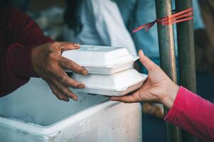 voedsel bijstand naar de dakloos arm van vrijwilligers concepten van openbaar honger. foto