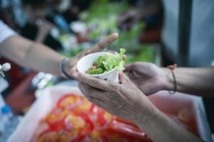 schenken overgebleven voedsel naar hongerig mensen, concept van armoede en honger foto