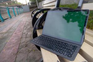 laptop tablet met blanco scherm Aan park bank. foto