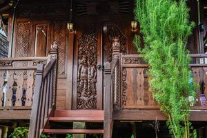 de voorkant visie van een klassiek houten huis, vol van kenmerkend houtsnijwerk met Javaans Indonesisch nuances. foto
