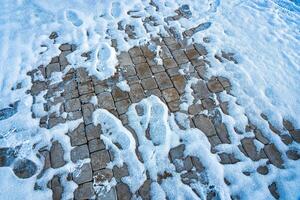 bestrating paden in de park, gedekt met de eerste sneeuw in winter. foto