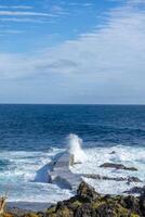 krachtig golven Botsing langs de kustlijn van cinco ribeira's, een toneel- het baden Oppervlakte Aan terceira eiland, azoren. foto