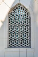 de venster van een moslim moskee achter bars in de het formulier van een meetkundig zeshoekig Islamitisch ornament. foto