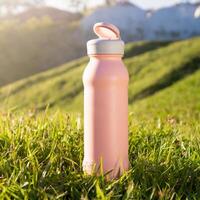 fles van sport drinken Aan gras, natuur achtergrond, Gezondheid leven concept foto