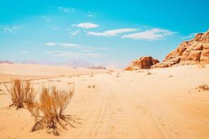 toneel- wadi rum woestijn panorama in heet zonnig dag met auto sporen Aan zand. beroemd filmen locaties van films foto