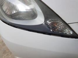 de wit honda jazz- koplamp glas is beschimmeld foto