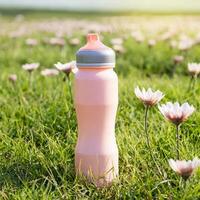 fles van sport drinken Aan gras, natuur achtergrond, Gezondheid leven concept foto