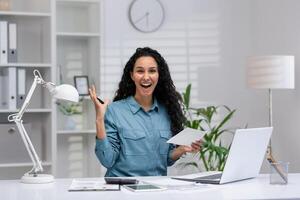 vrolijk spaans zakenvrouw in een huis kantoor instelling, opgewonden bespreken werk zaken over- een telefoongesprek, belichamen produktiviteit en professionaliteit in een comfortabel omgeving. foto