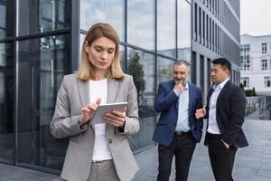 Intimidatie Bij werk, groep van bedrijf mensen buiten kantoor gebouw, mannen bespreken achter vrouw die van de baas rug, roddelen en stalken foto