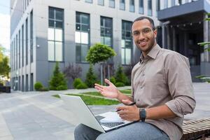 portret van jong gelukkig Afrikaanse Amerikaans Mens, leerling buiten campus glimlachen en op zoek Bij camera, leraar gebruik makend van laptop voor online aan het leren en roeping met studenten. foto