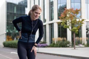 vrouw in geschiktheid kleding geklemd haar kant in ongemak terwijl rennen, tonen de uitdaging van buitenshuis oefening. foto