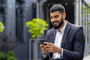 glimlachen zakenman gebruik makend van smartphone met oortelefoons buitenshuis foto