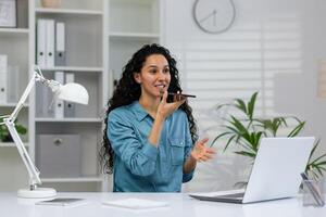 gefocust professioneel in huis kantoor opstelling verloofd in een echt telefoon gesprek met een laptop en bureau lamp. foto