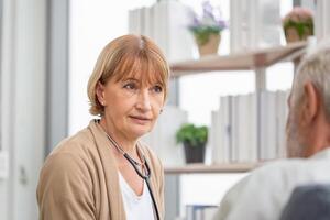 vrouw dokter bezoekende ouderen Mens Bij huis, Gezondheid bezoeker, en een senior Mens gedurende huis bezoek foto