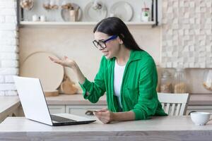 vrouw teleurgesteld verdrietig en boos Bij huis in de keuken proberen naar maken een online aankoop foto