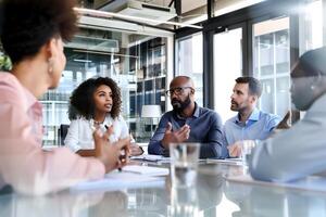 portret van een groep van professionals zittend in de omgeving van een conferentie tafel in een kantoor ruimte foto