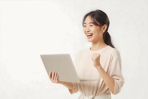 een jong Aziatisch vrouw staat Holding een laptop met een uitdrukking van vreugde foto