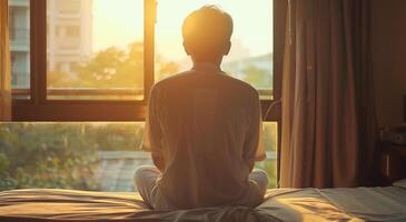 terug visie van jong Mens mediteren Aan de bed in de ochtend- foto