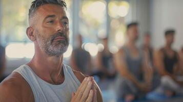 een mannetje yoga instructeur leidend de klasse met een medelevend en rustgevend aanwezigheid leidend de mannen naar een herstellend en genezing ervaring foto