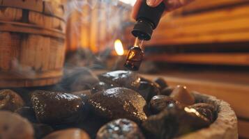 detailopname van een personen hand- Holding een essentieel olie druppelaar toevoegen een weinig druppels naar de heet rotsen binnen de sauna. foto