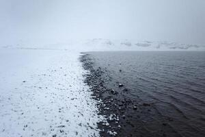 zwart en wit reynisfjara vulkanisch strand met basalt beeldhouwwerk kolommen verhogen omhoog van de zee. IJsland, Europa. foto