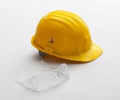 geel helm en bril voor veiligheid Bij werk. foto