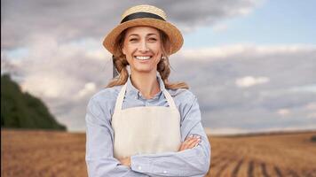 vrouw boer rietje hoed schort staand bouwland glimlachen vrouw agronoom specialist landbouw agribusiness gelukkig positief Kaukasisch arbeider agrarisch veld- foto