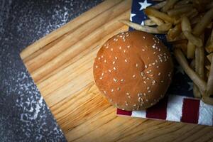 kaas hamburger - Amerikaans kaas hamburger met gouden Frans Patat Aan houten bord foto