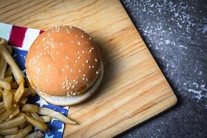kaas hamburger - Amerikaans kaas hamburger met gouden Frans Patat Aan houten bord foto