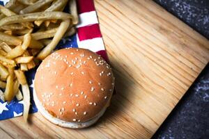 kaas hamburger - Amerikaans kaas hamburger met gouden Frans Patat Aan houten bord foto