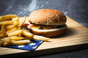 kaas hamburger - Amerikaans kaas hamburger met gouden Frans Patat Aan houten bord foto