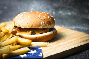 kaas hamburger - Amerikaans kaas hamburger met gouden Frans Patat Aan houten bord foto