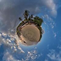 kokosnoot bomen in oerwoud in Indisch keerkring dorp Aan zee kust Aan weinig planeet in blauw lucht, transformatie van bolvormig 360 panorama. bolvormig abstract visie met kromming van ruimte. foto
