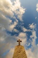 silhouet van steen graf kruis tegen de achtergrond van een blauw avond lucht met wolken foto