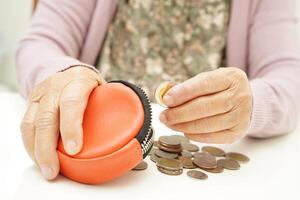 gepensioneerd ouderen vrouw tellen munten geld en zich zorgen maken over maandelijks onkosten en behandeling vergoeding betaling. foto