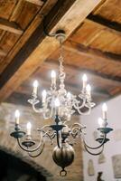 bronzen gloeiend kroonluchter met bollen en kaars lampen blijft hangen van een houten plafond foto