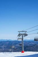 stoeltjeslift in bergen gedurende zonnig winter dag. foto