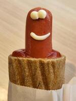 hotdog versierd met saus. openbaar horeca. worst in deeg foto