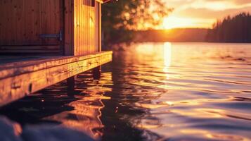 de warm licht van de sauna reflecterend uit de oppervlakte van een rustig meer Bij zonsondergang. foto