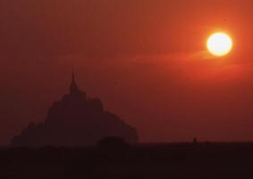 de zon sets achter een berg in de achtergrond foto