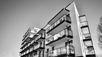 fragment van een facade van een gebouw met ramen en balkons. modern appartement gebouwen Aan een zonnig dag. facade van een modern appartement gebouw. zwart en wit. foto